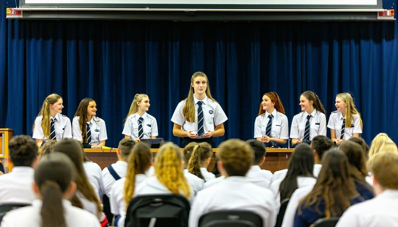 Australian high school students male and female aged 1718 presenting in front of their peers in the classroom or on stage they are all in uniform and are showing the leadership skill growth
